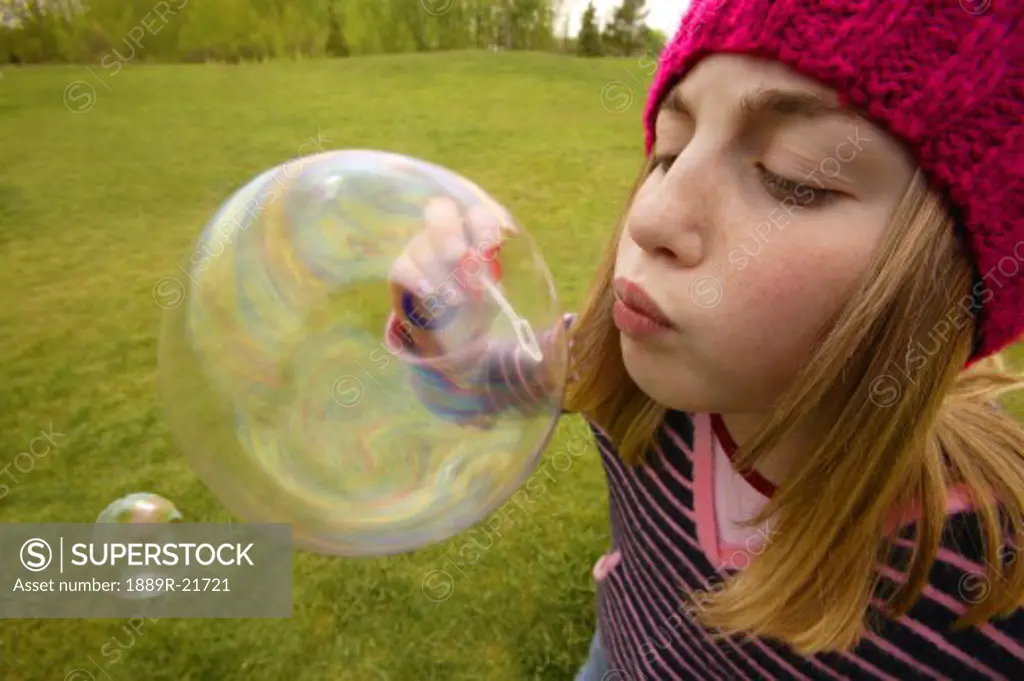 Child blows a bubble