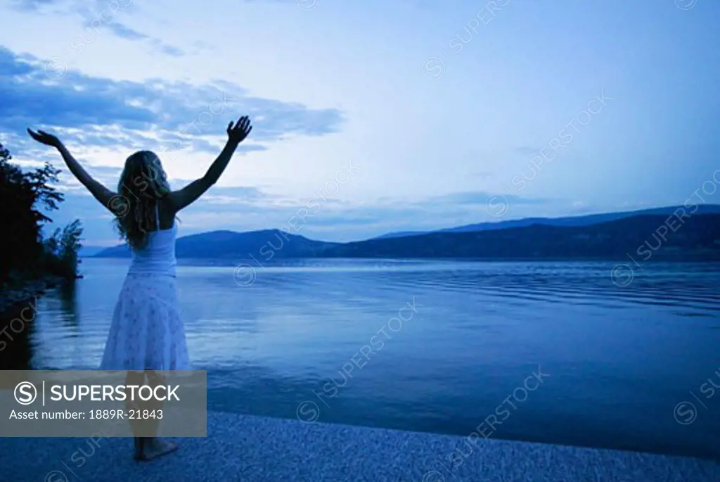 Woman lifts her hands towards heaven