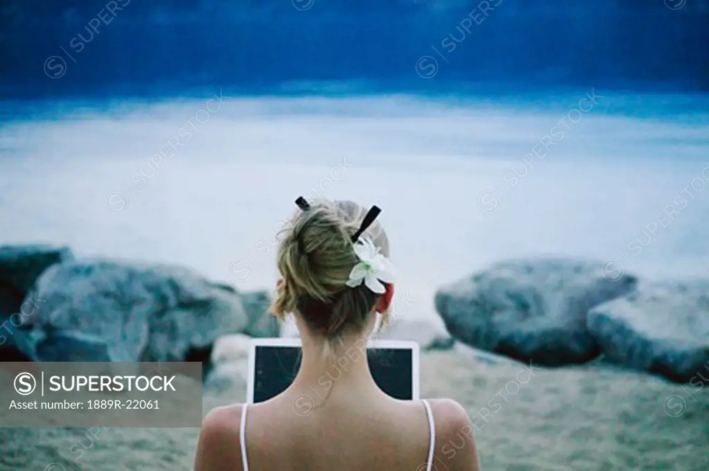Woman works on lap top computer at the lake