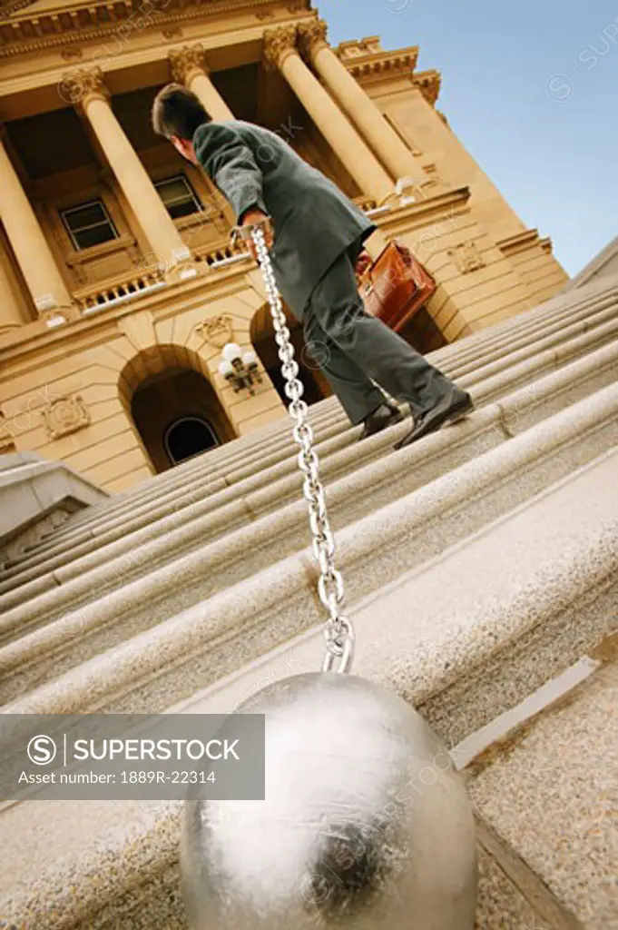 Businessman carrying a ball and chain