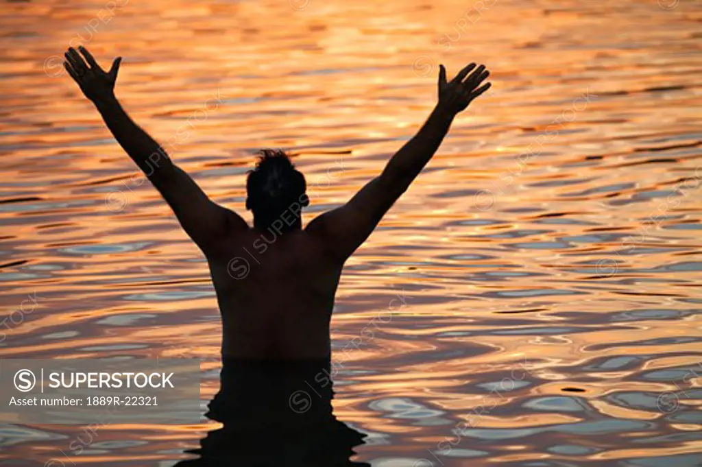 Man with arms raised in water