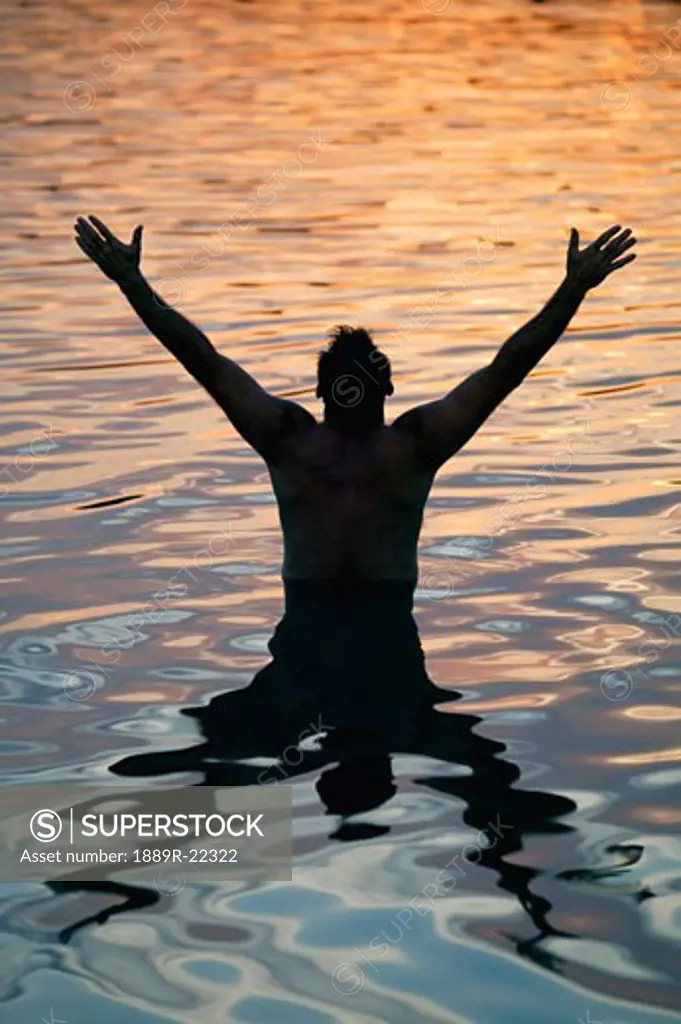 Man with arms raised in water