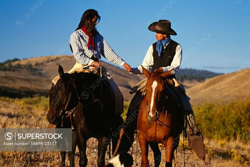Cowboy and cowgirl on horseback