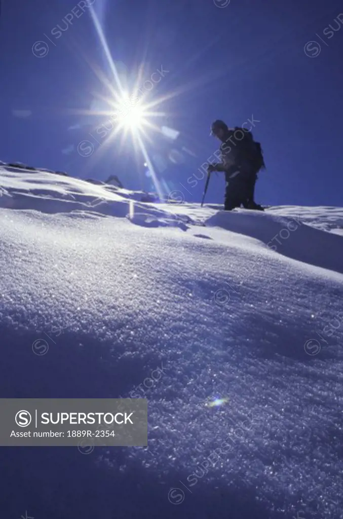 Lone mountaineer walking on snow