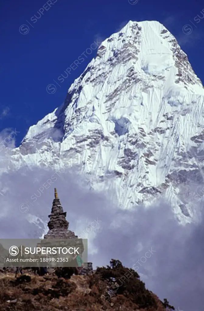 Mountain peak in the clouds behind cultural monument