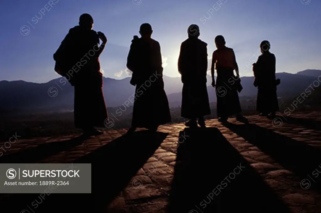 Five Buddhist monks in silhouette
