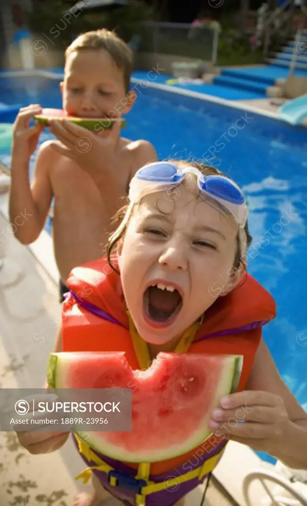 Kids eating watermelon at poolside