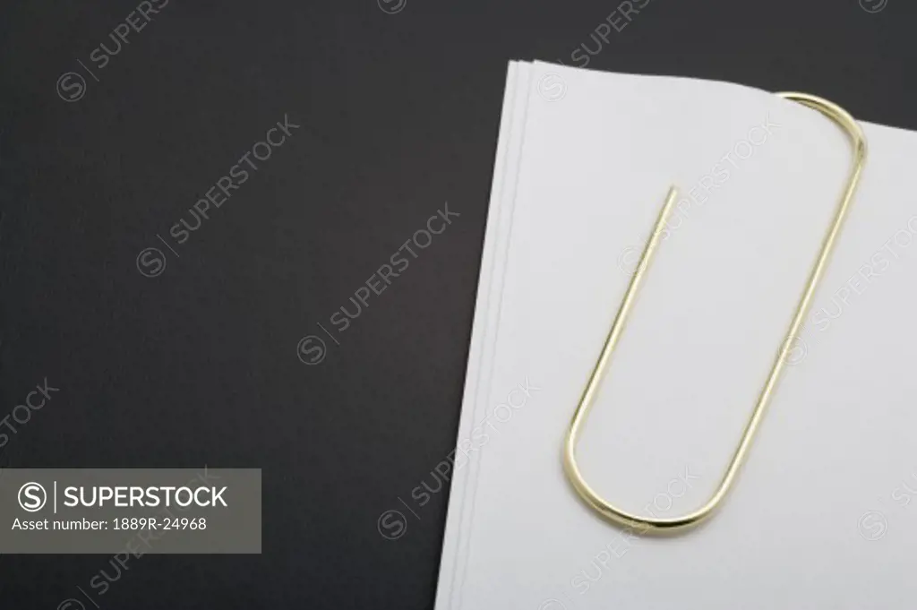 White paper clipped with gold paper clip