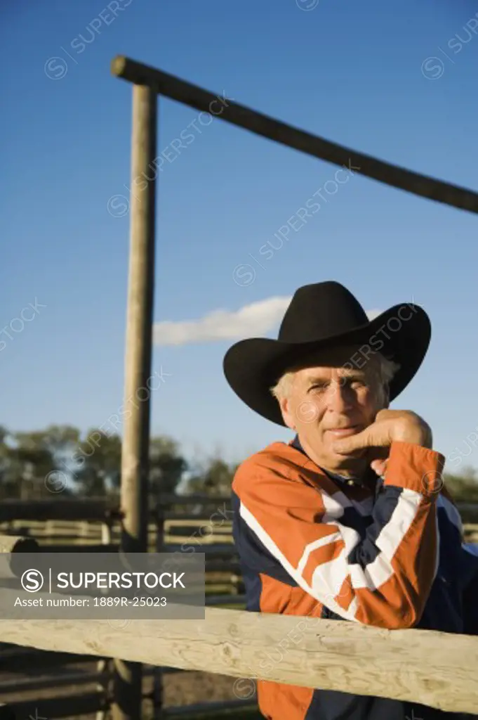 Rancher leaning on a corral