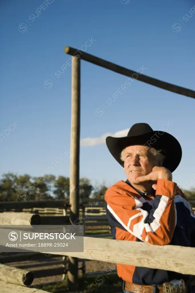Rancher leaning on a corral