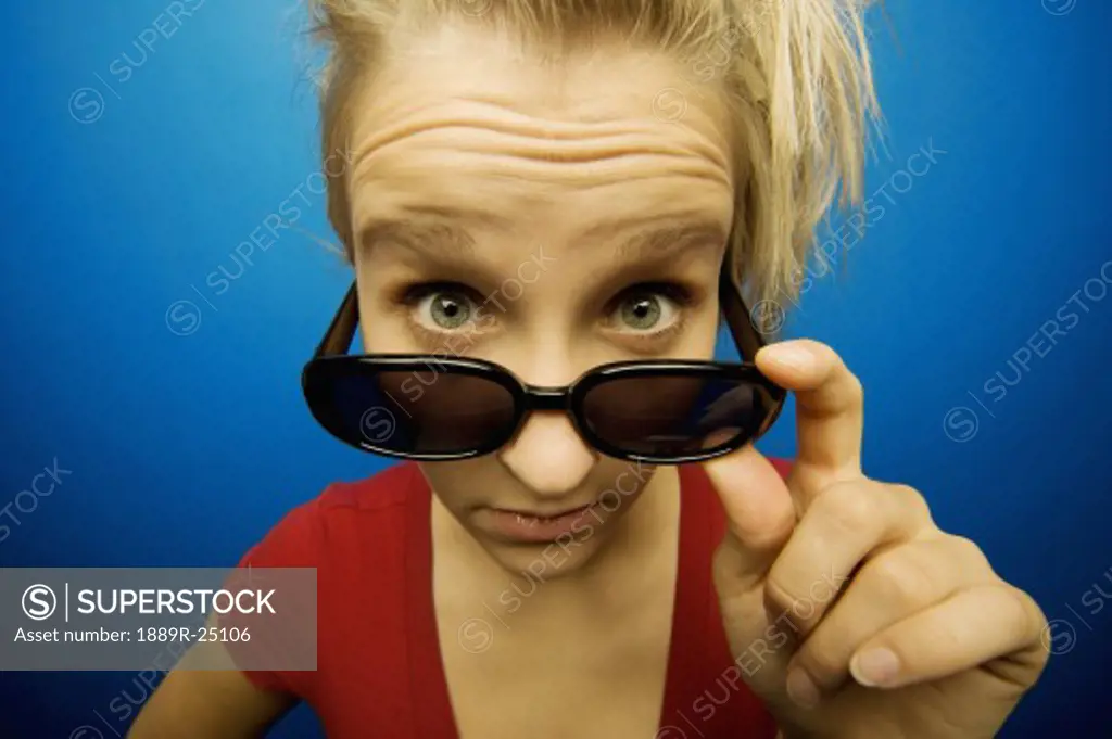 Young woman wearing sunglasses looking surprised