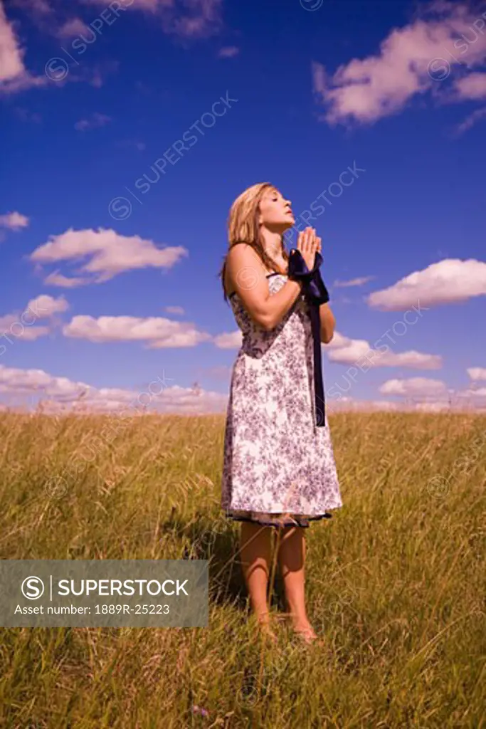 Woman praying in a field