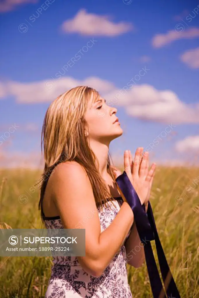 Woman praying in a field