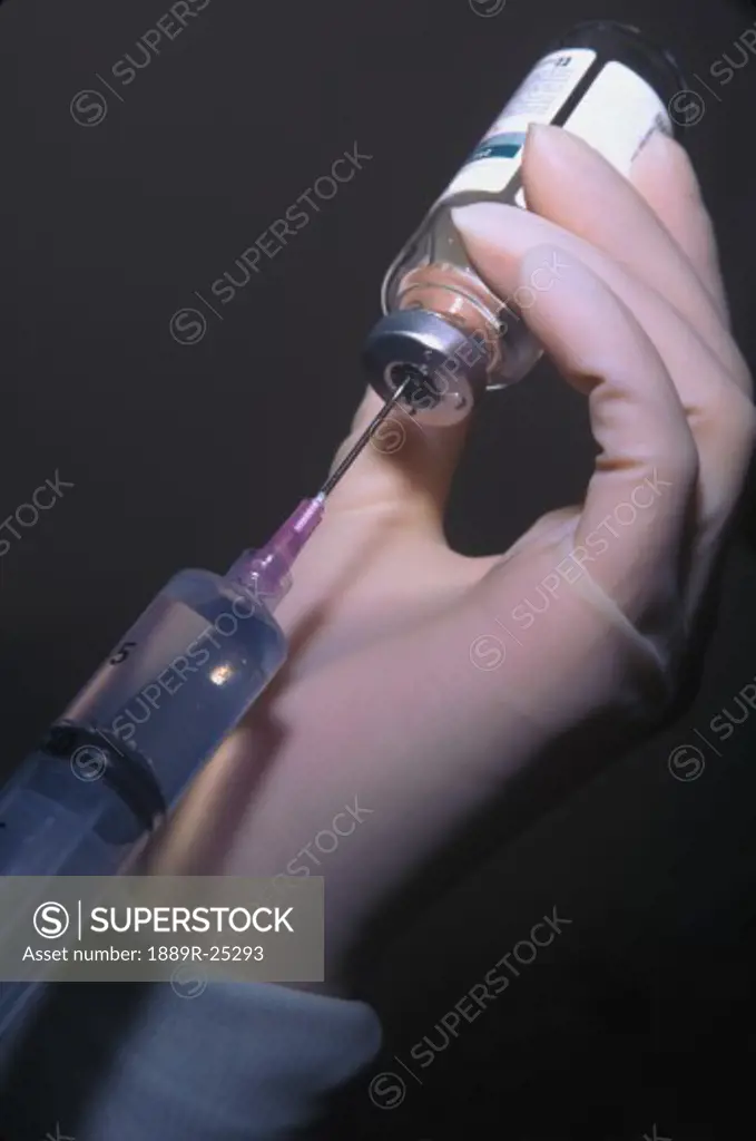 Health professional filling syringe