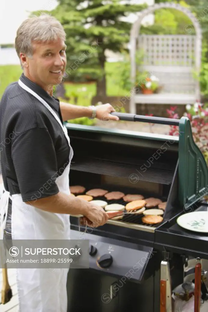 Man barbecuing burgers