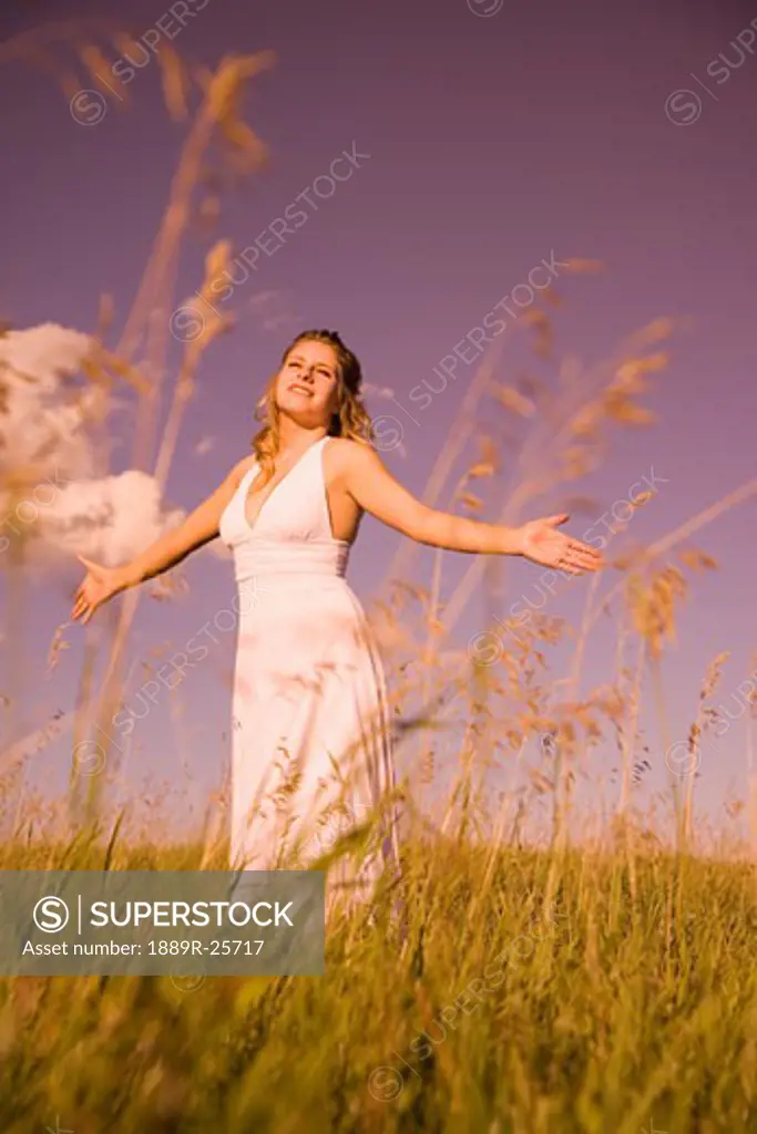 Young woman worshipping in a field