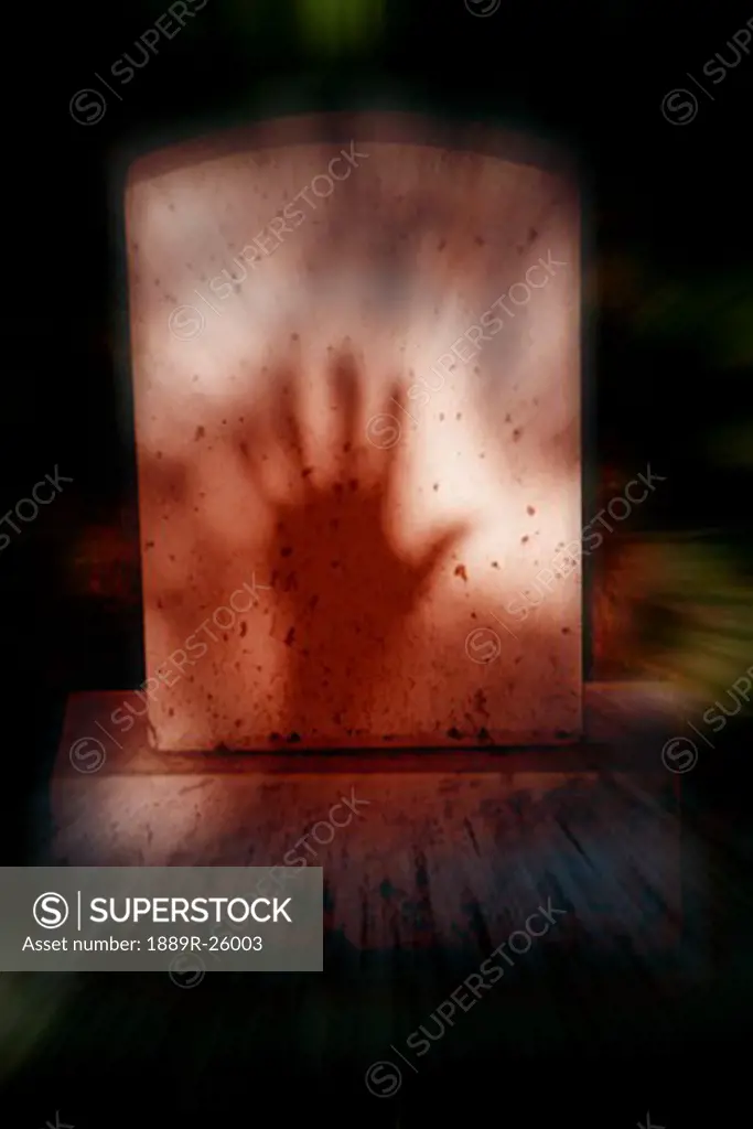 Shadow of hand on tomb stone
