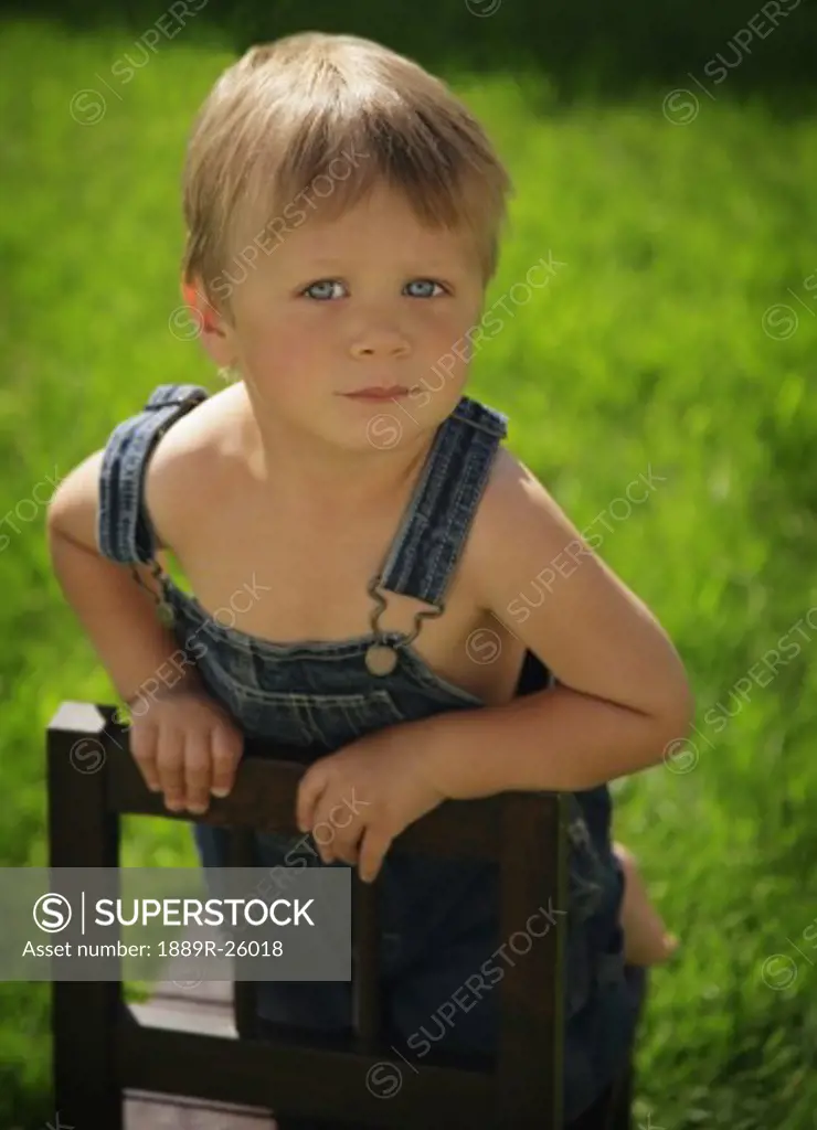 Boy leaning on chair