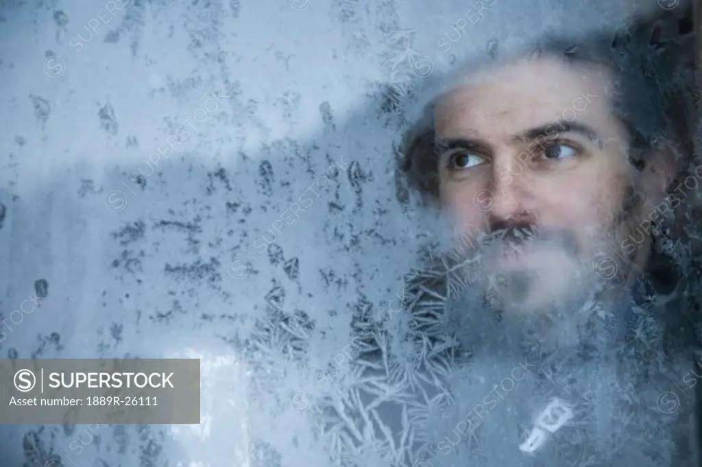 Man looking through frosted glass