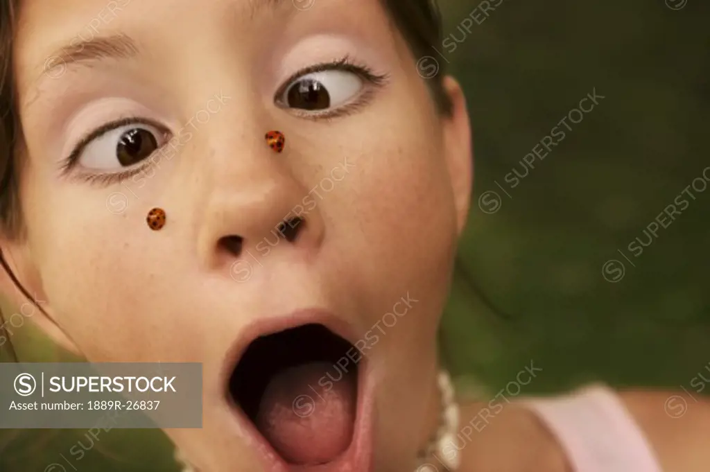 Girl with ladybugs on her face