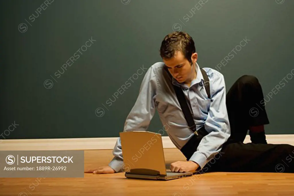 Man using laptop on the floor