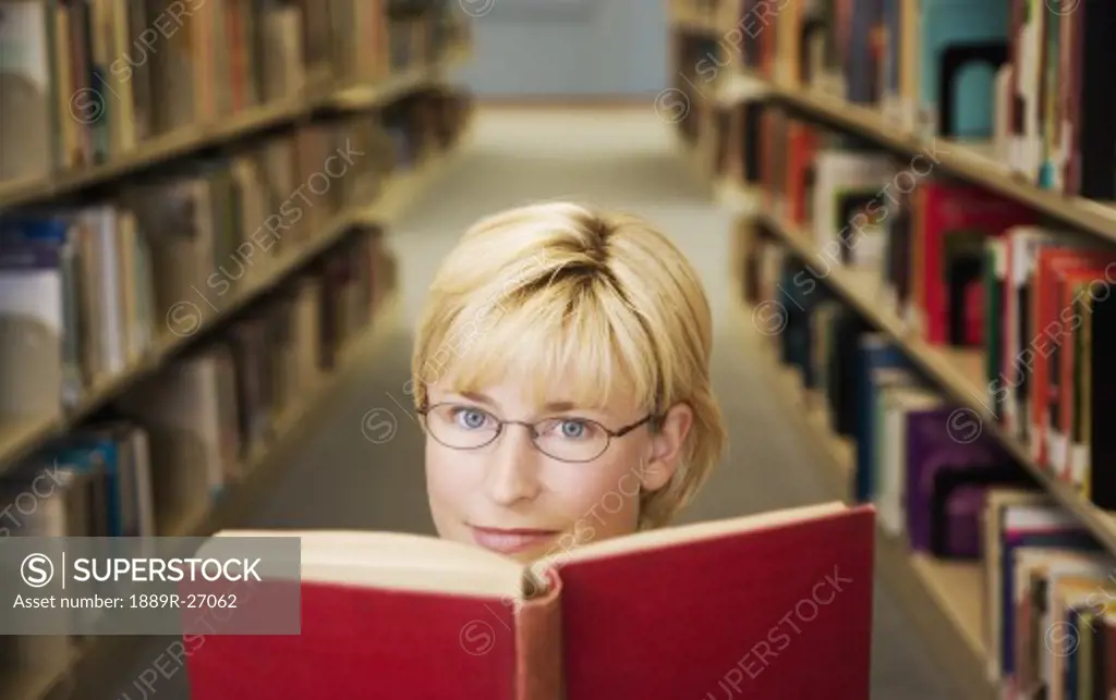 Woman looking up from a book in the library