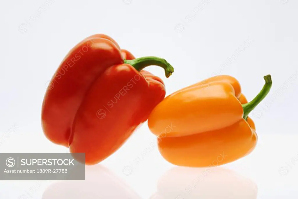 Red pepper leaning on an orange pepper