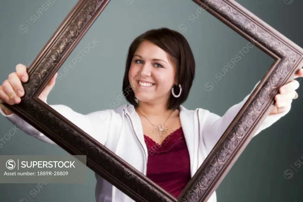 Woman smiling while holding a picture frame