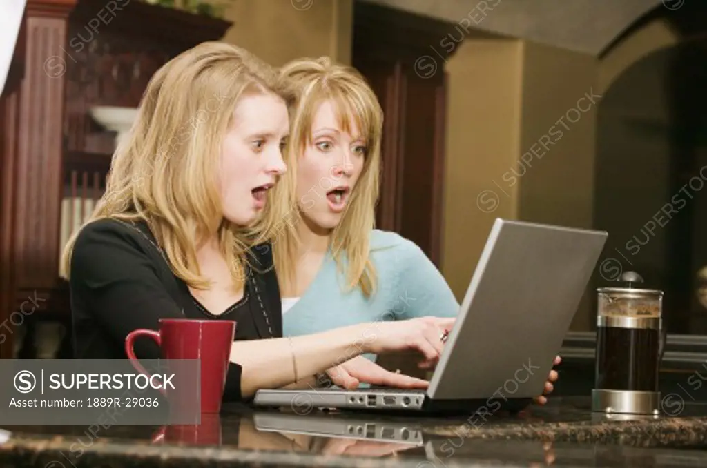 Woman with surprised expressions looking at a laptop