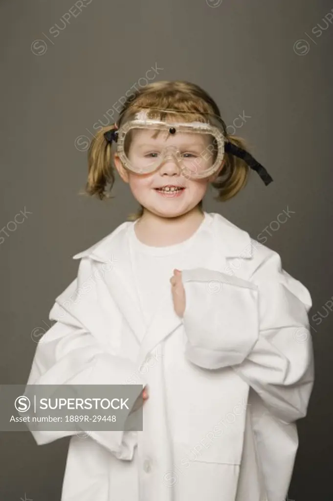 Little girl in white coat and safety goggles
