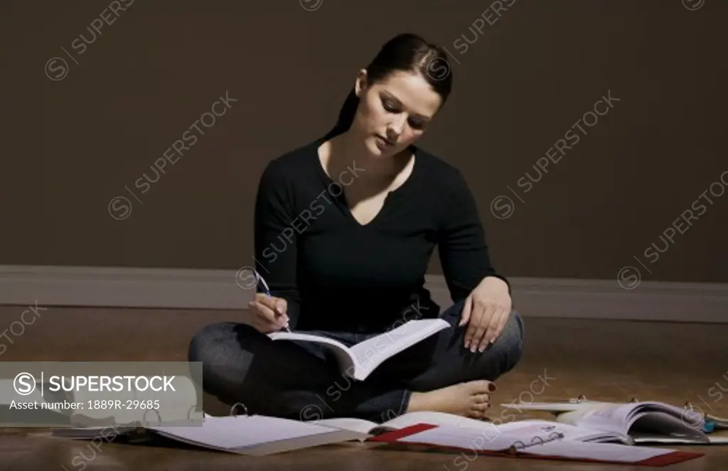 Young woman studying on the floor