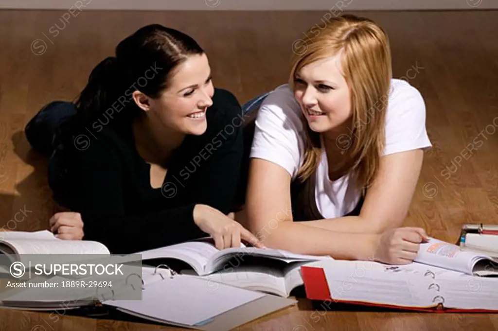 Two women studying on the floor
