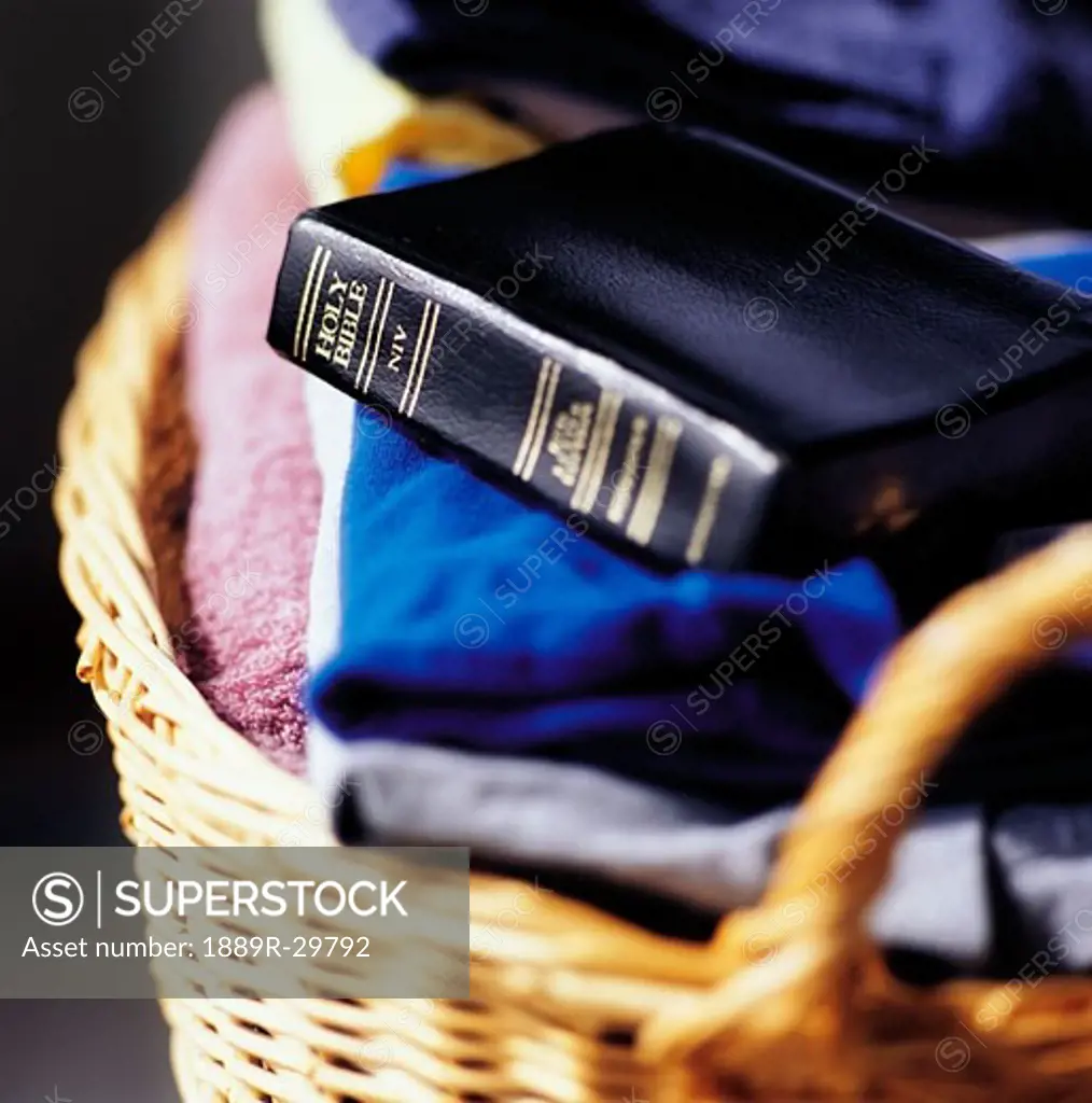 Bible on top of laundry folded in basket
