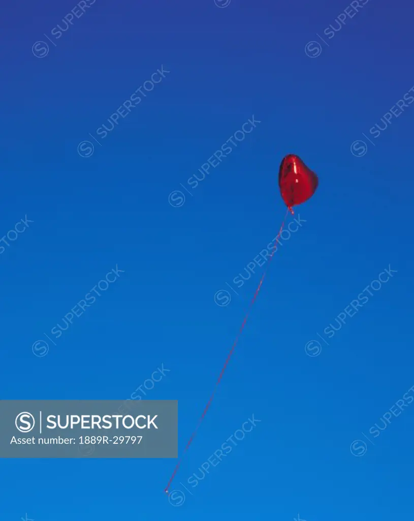 A heart-shaped balloon in the sky