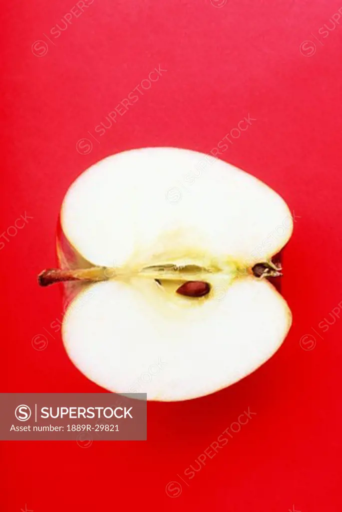 Half an apple on red background