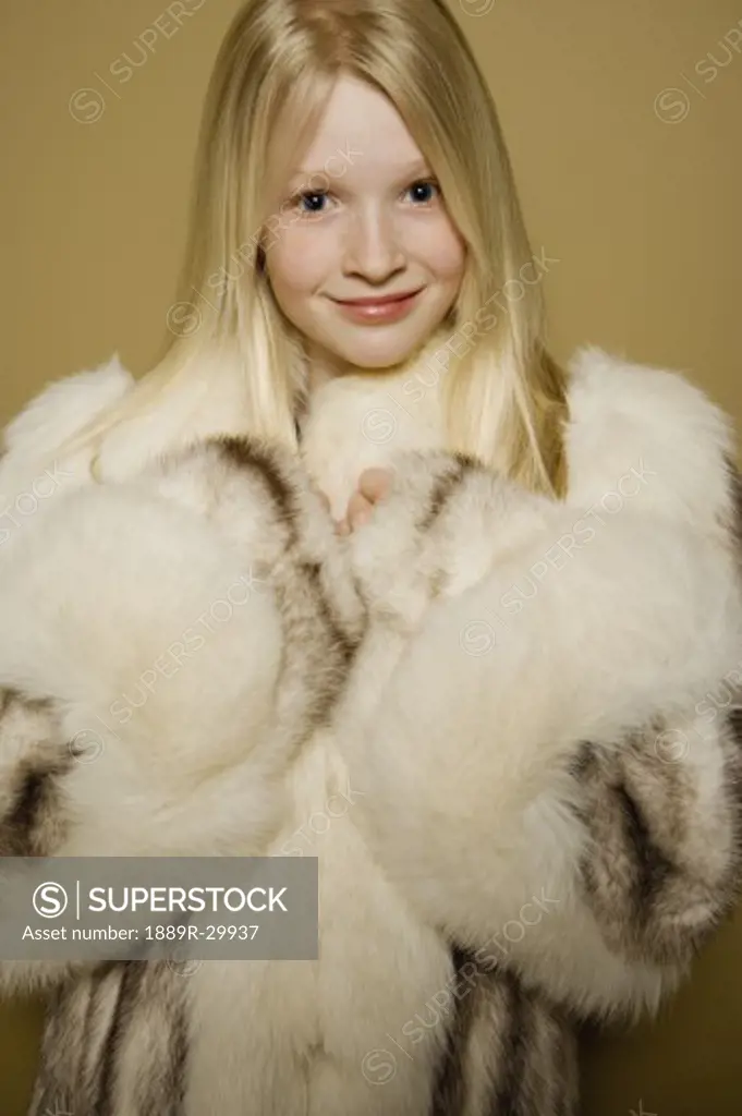 Little girl in a large fur coat