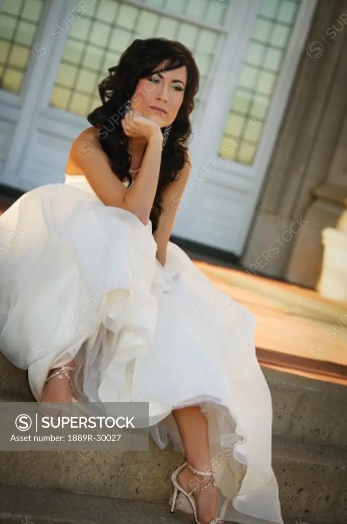 Bride sitting on steps and thinking
