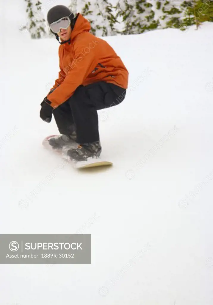 Snowboarder going down snowy hill
