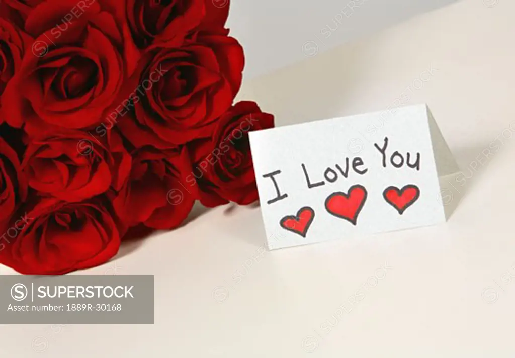 I love you card beside roses