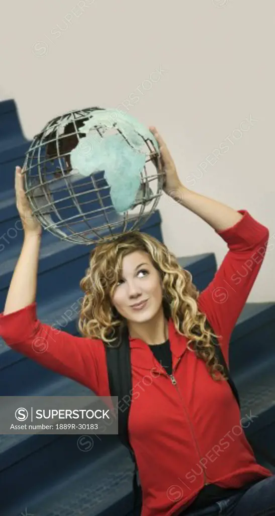 Girl holding globe on her head