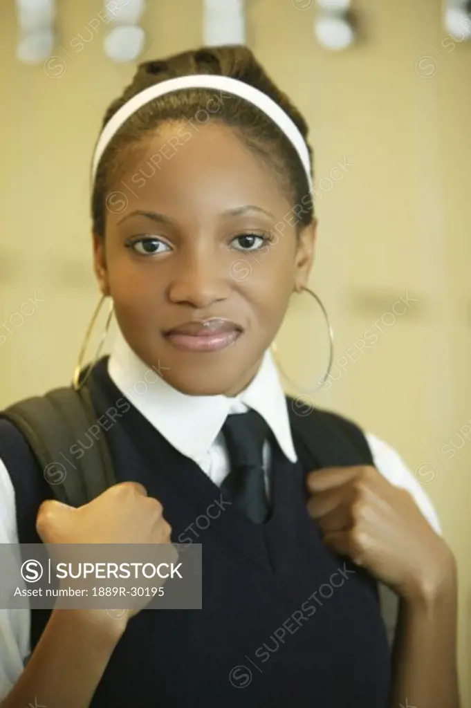 Female student in uniform with backpack on