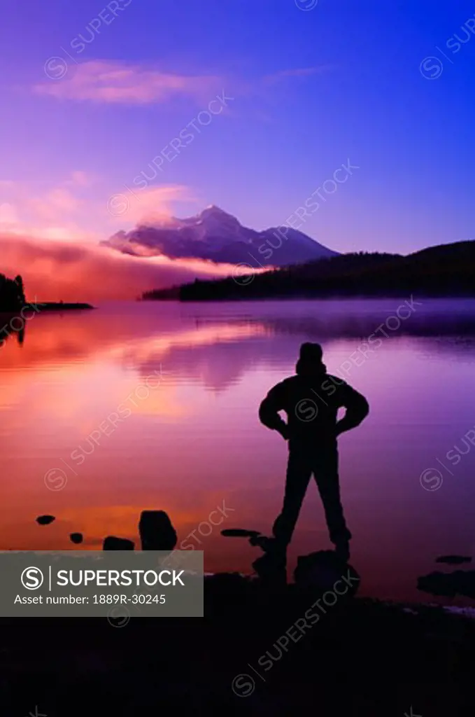 Silhouette of a man at a mountain lake  