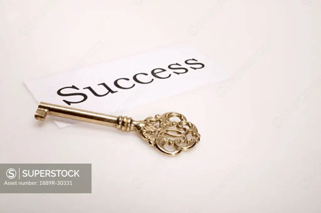A gold key with the word 'success' written beside it