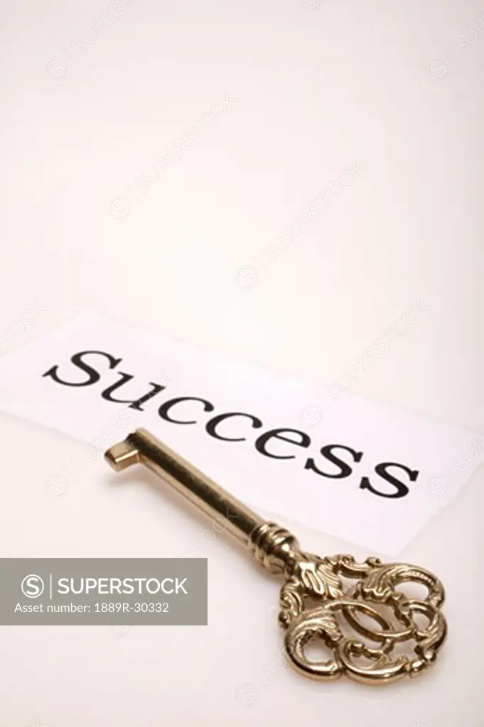 A gold key with the word 'success' written beside it