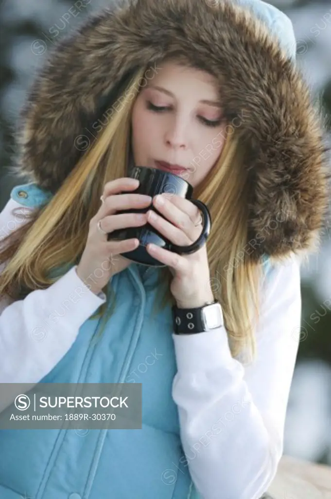 Woman drinking hot drink outside