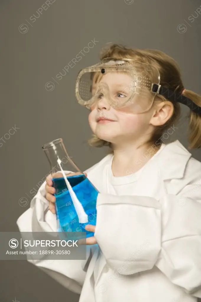 Little girl with safety goggles and science beaker