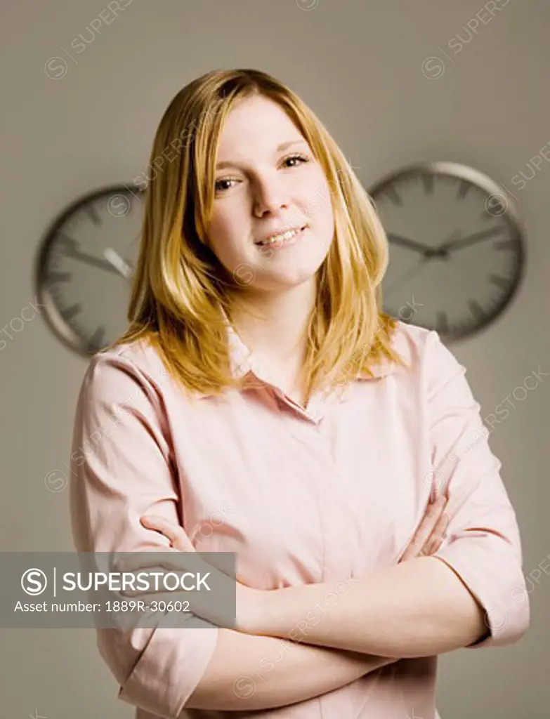 Portrait of woman in front of clocks