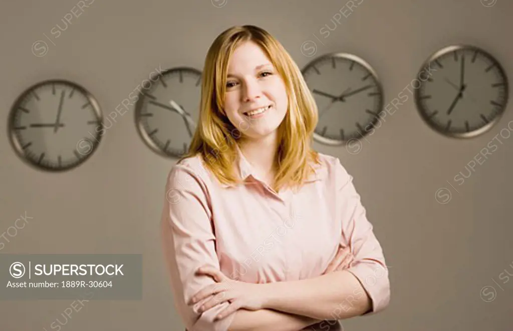 Woman standing in front of clocks