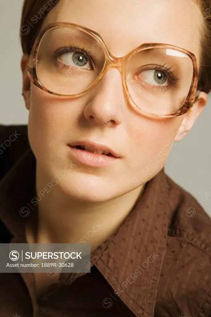 Woman wearing spectacles, looking up