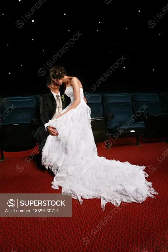 A newlywed couple kissing indoors